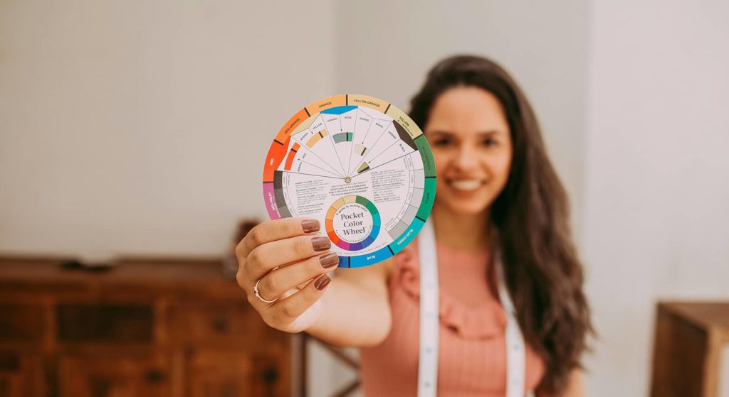 Image d'une femme présentant une roue chromatique pour illustrer l'article sur comment choisir sa palette de couleur pour son identité visuelle.